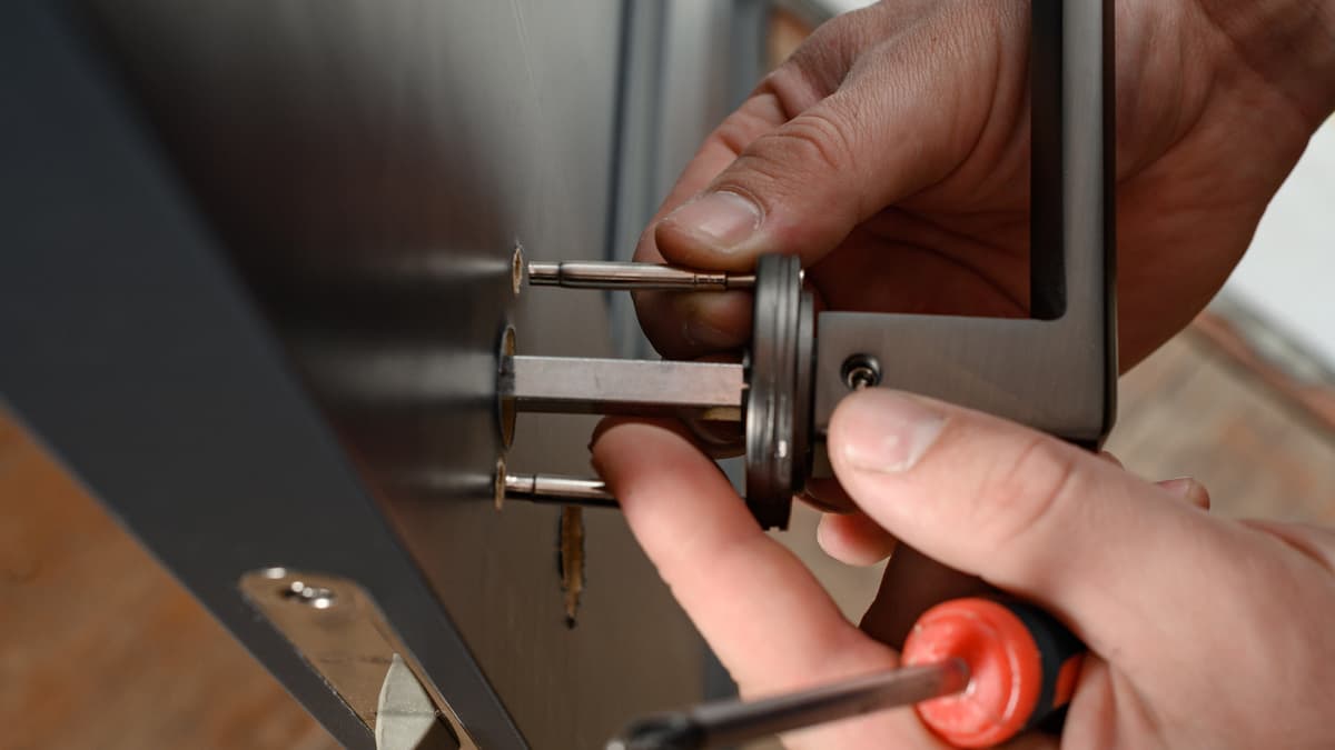 Hands installing a lever handle on an interior door